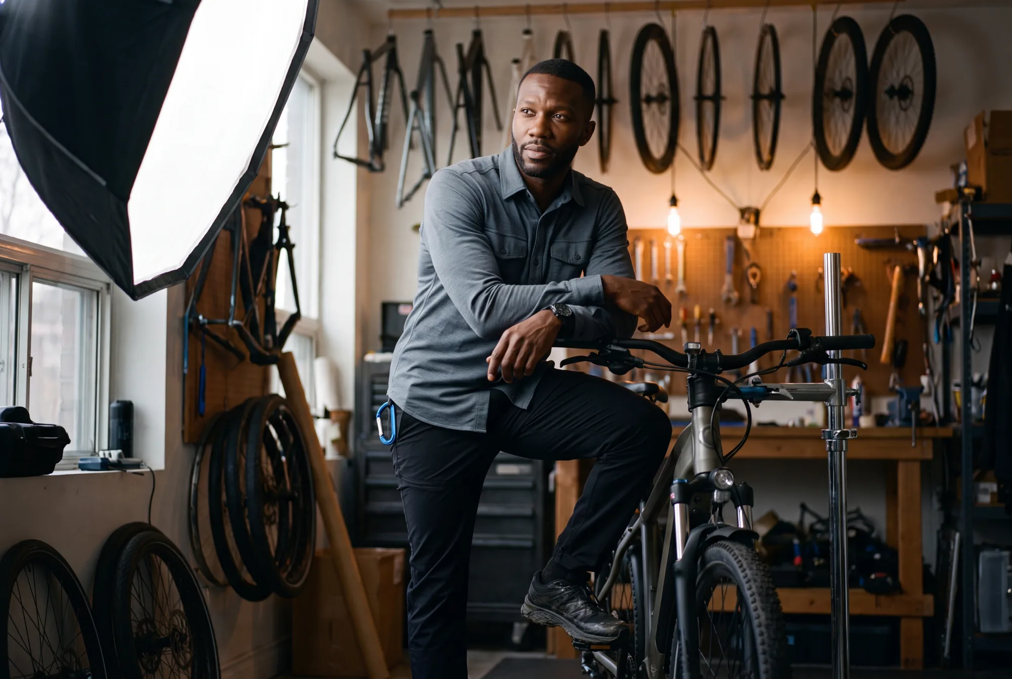 A field editor standing with an e-bike among rows of frames in a workshop